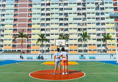 极简主义摄影的两个男人站在篮球场向上看
